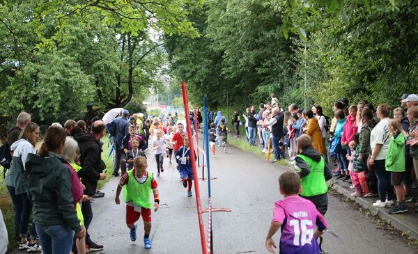 Auf der Laufstrecke sind viele laufende Kinder zu sehen.