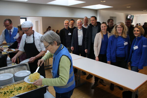 An die Schöpfkellen griffen zum Auftakt der Remchinger Vesperkirche Gunther Kirchbaum (von links), Monika und Matze Burger sowie Stefanie Seemann. Darüber freuten sich die Vertreter der Kirchengemeinden und Diakoniestation um den Vorsitzenden Karl-Heinz Stengel (hinten Dritter von links) und Bürgermeisterin Julia Wieland (Fünfte von rechts). Foto: Zachmann  